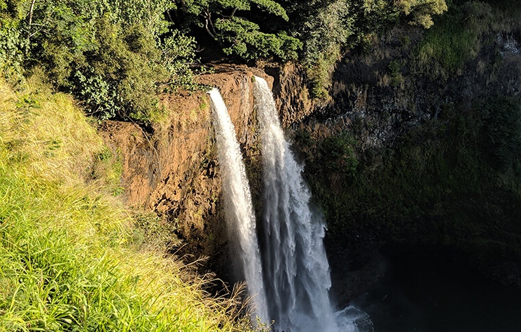 Cascading waterfall over sun soaked cliffs